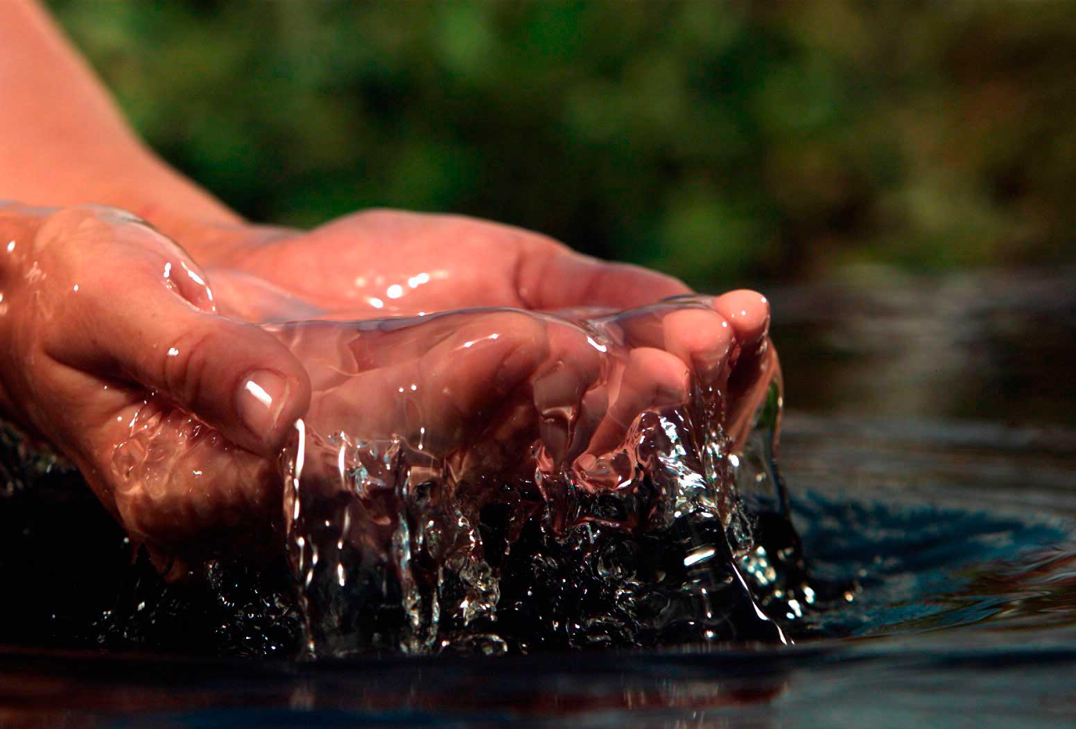 Imagen de una persona tomando agua de una olla agricola plastica